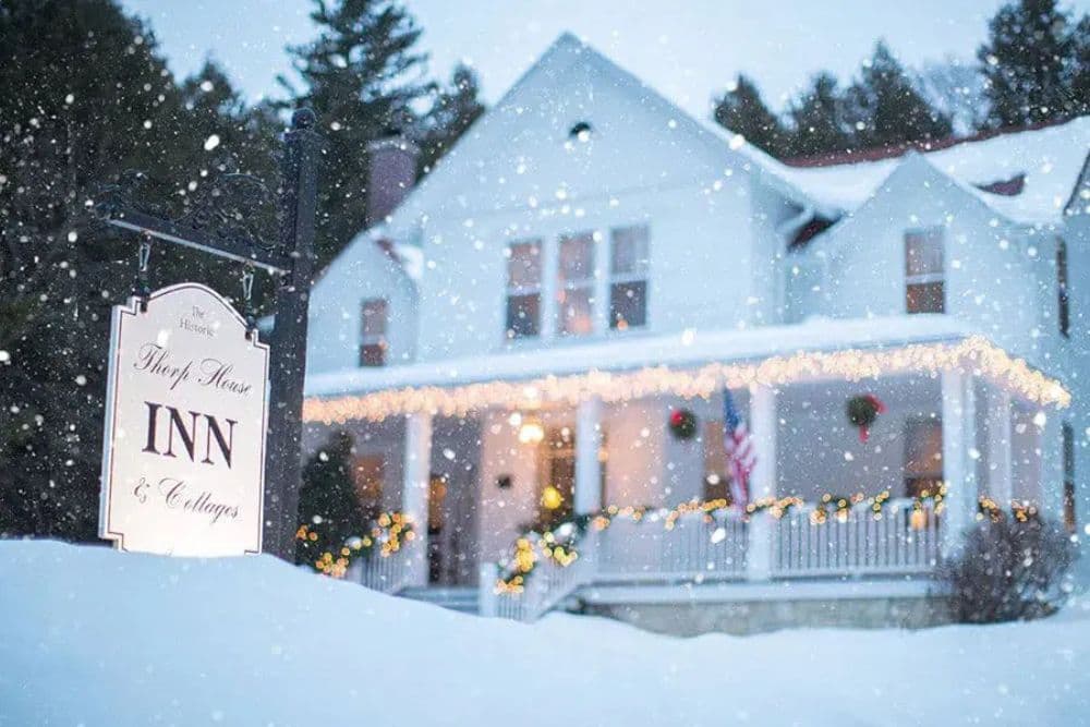 A snow-covered inn adorned with holiday lights and decorations.