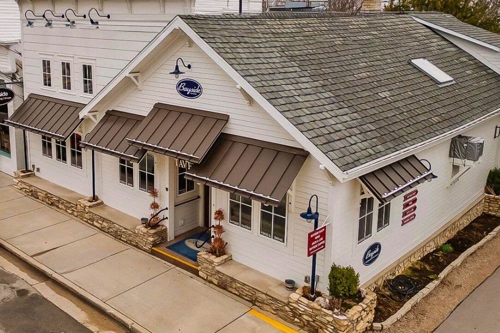 Aerial view of a white building with a sloped roof featuring the sign "Bayside."